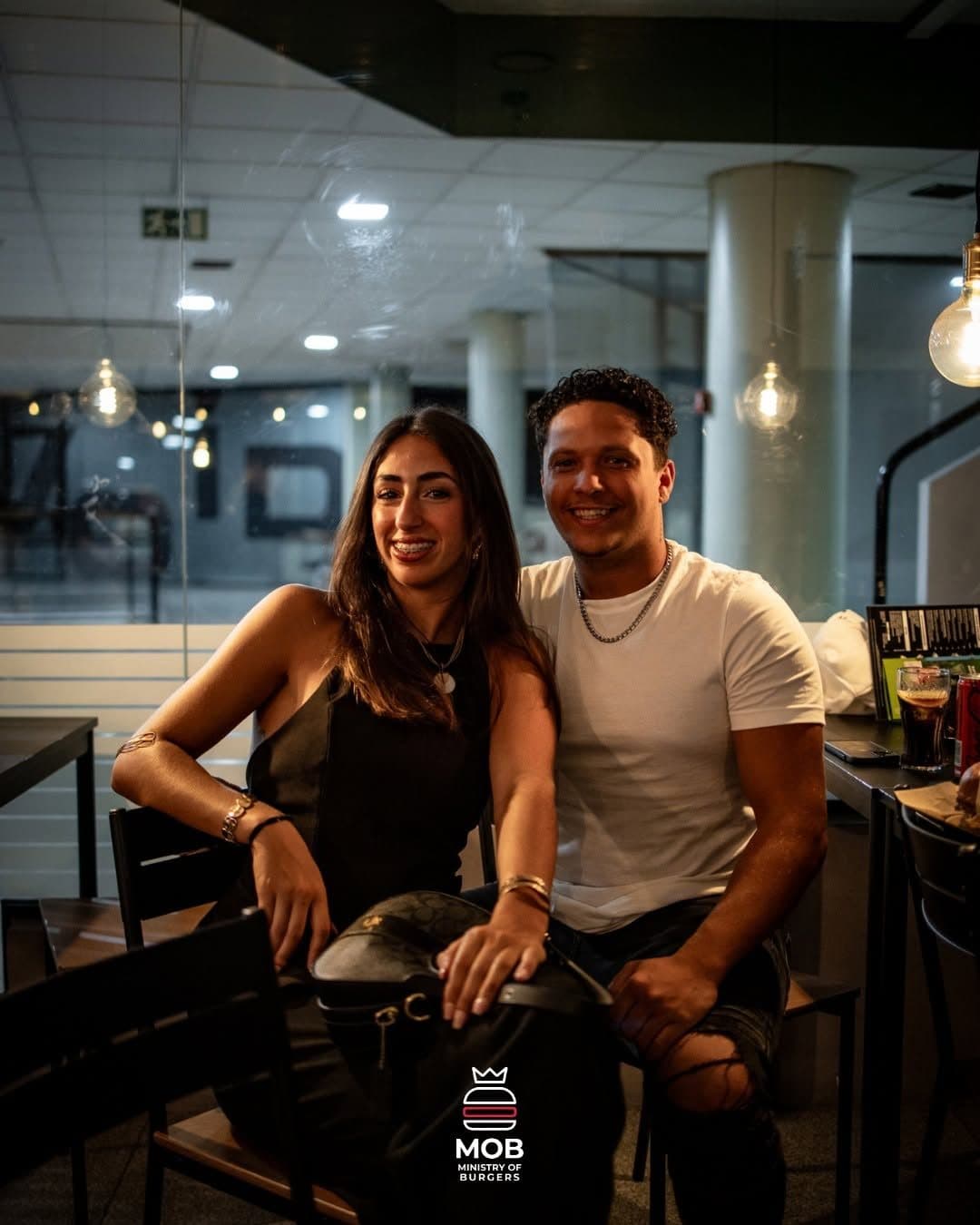 Dois amigos sentados lado a lado na sala da MOB