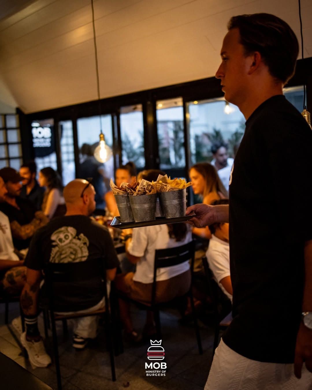 Sala cheia ao jantar, com o staff a servir as mesas